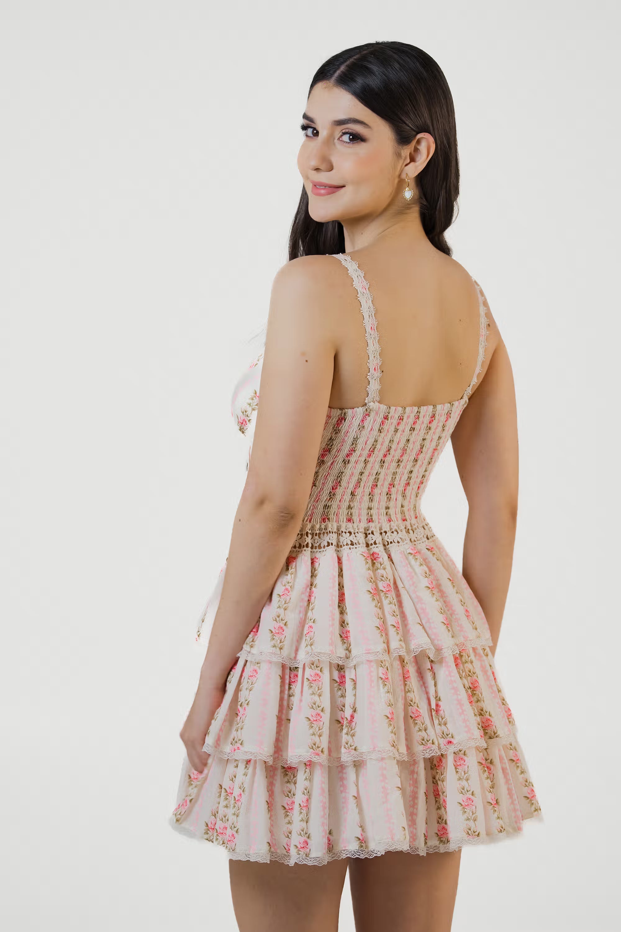 Back view of blush floral smocked tiered mini dress with lace straps and layered ruffle hem, elegant summer outfit for women