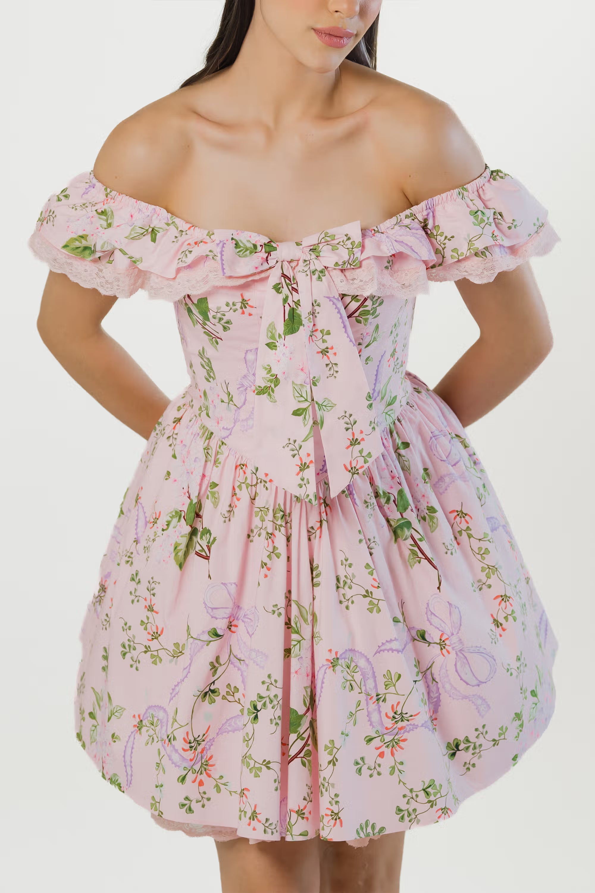 Closeup of pink floral off shoulder mini dress with front bow tie and ruffle lace trim