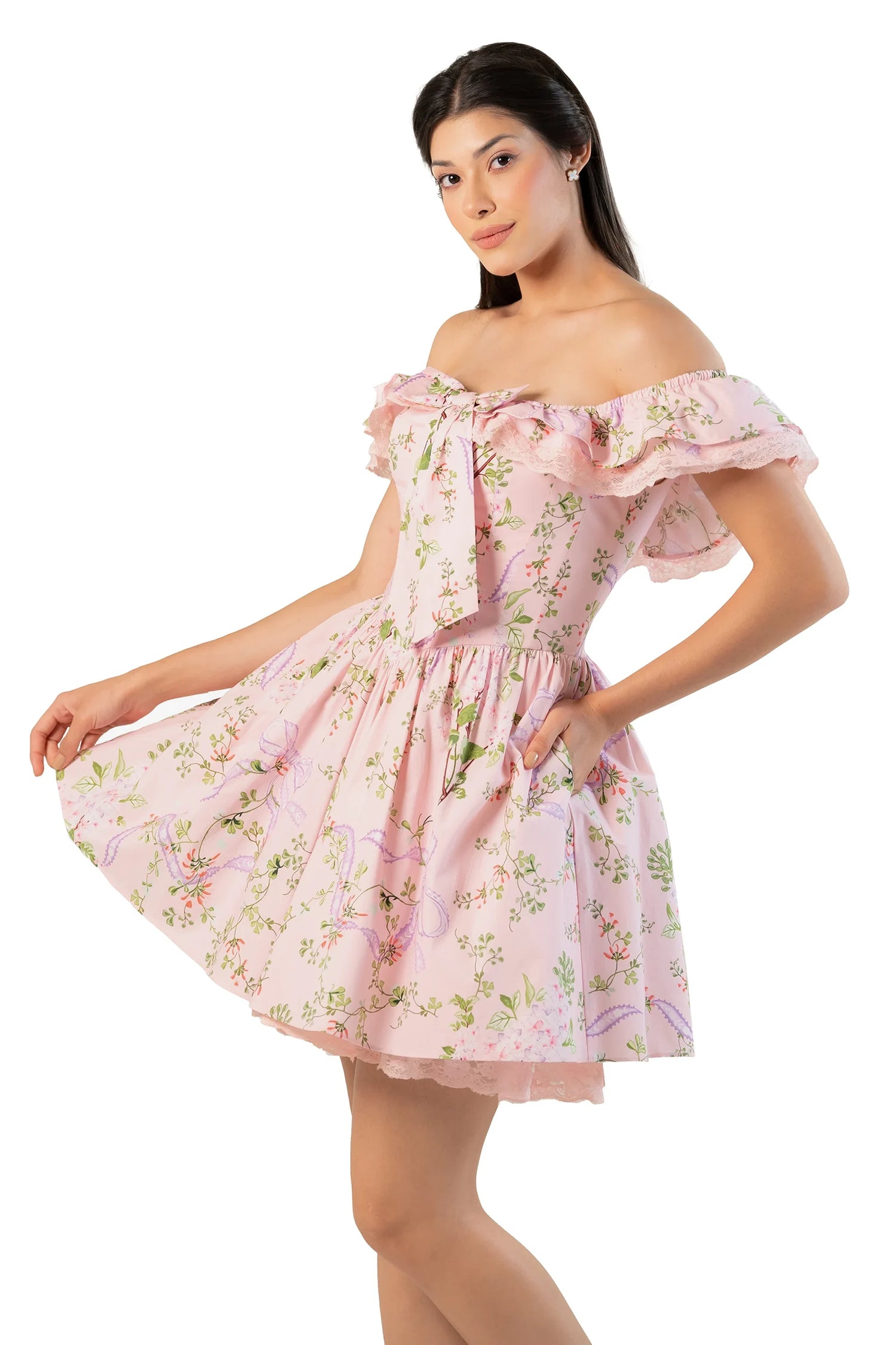 Side-angle view: women’s pink floral off-shoulder mini dress with lace ruffle, bow detail and practical pockets