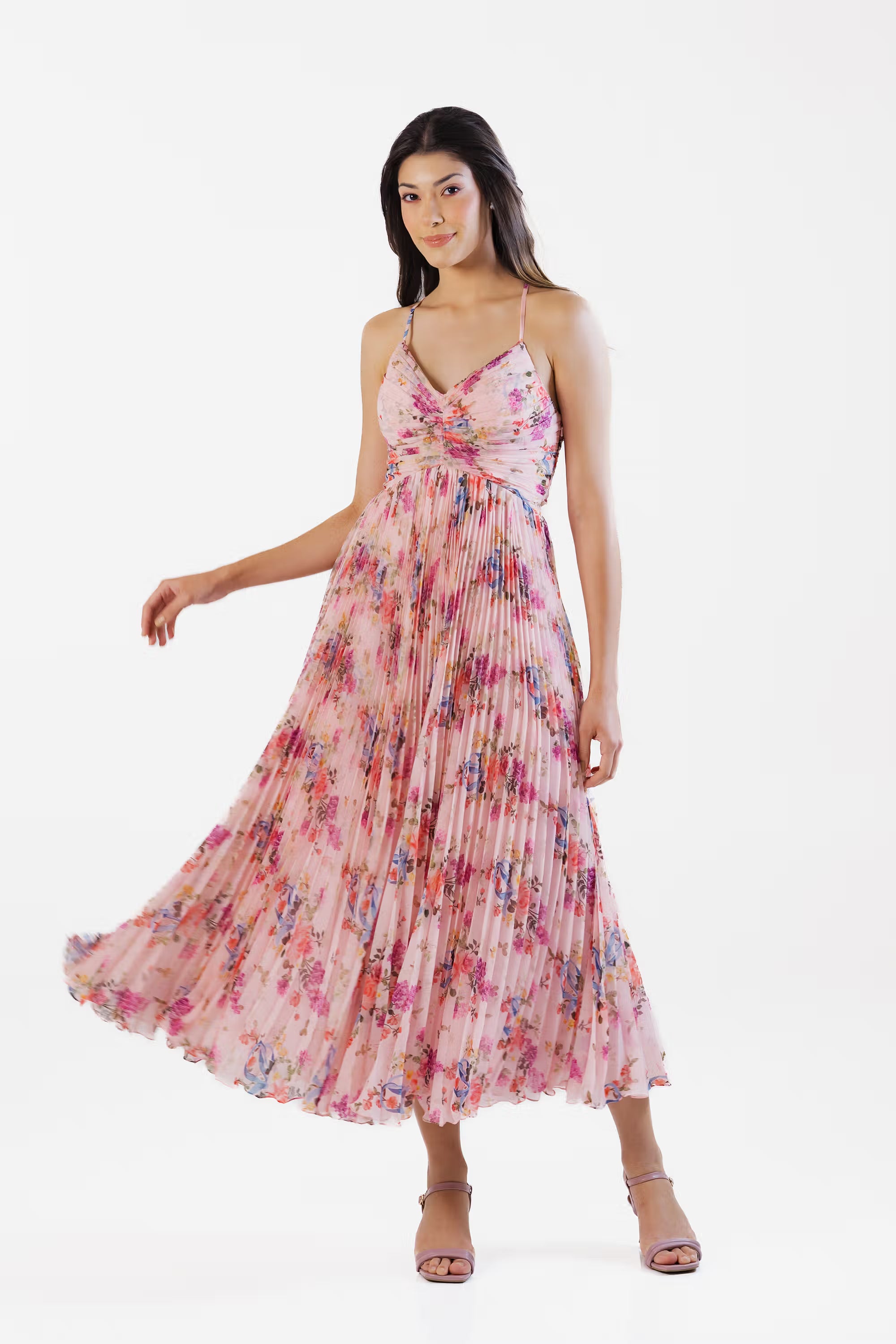 Women wearing pink floral pleated maxi dress with v-neckline and flowy skirt, front full view.