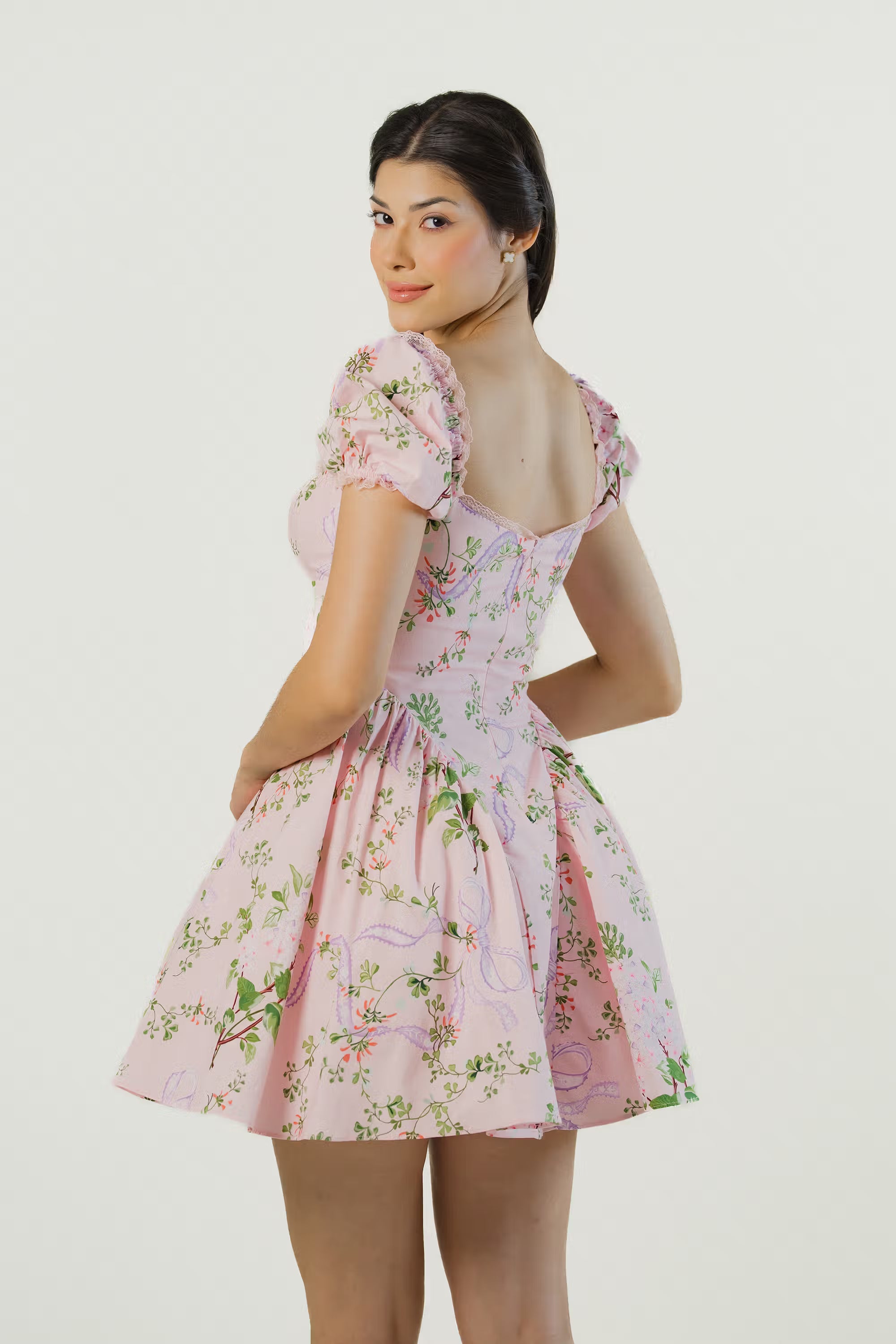 Back view of pink puff sleeve floral mini dress with flared skirt and feminine silhouette.
