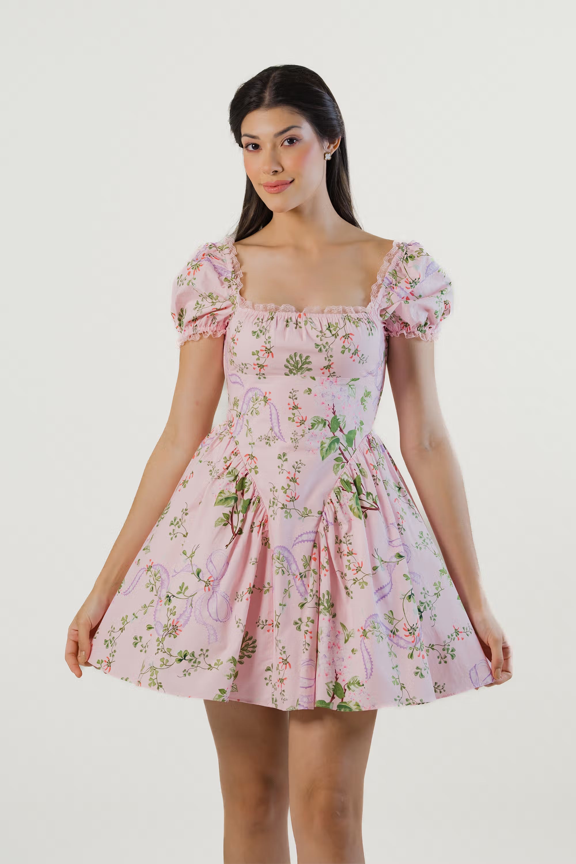 Closeup front view of pink puff sleeve mini dress featuring delicate floral print and fitted bodice.