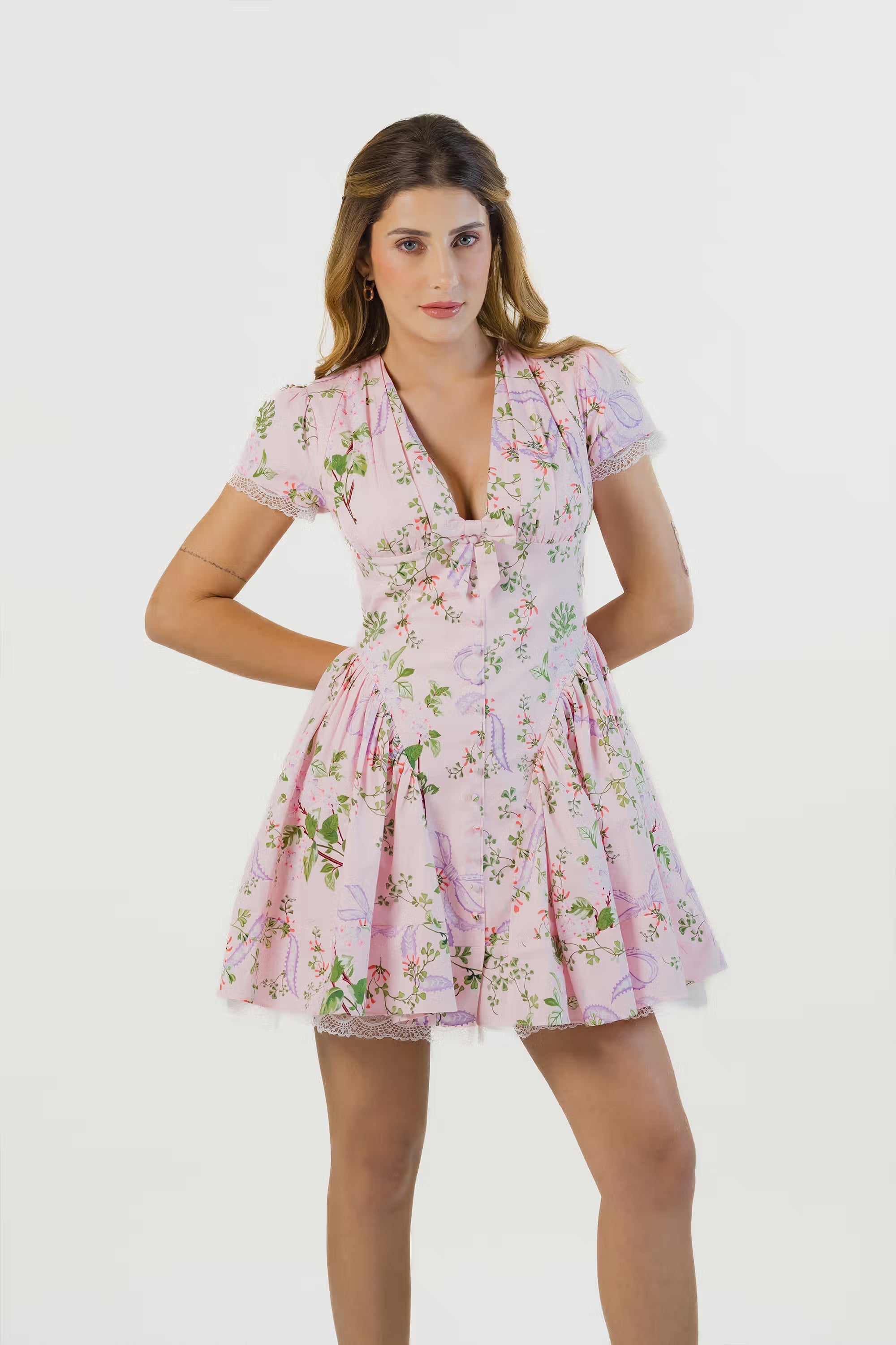 Model in pink floral short dress with lace trim, front view, v-neckline and puff sleeves for women