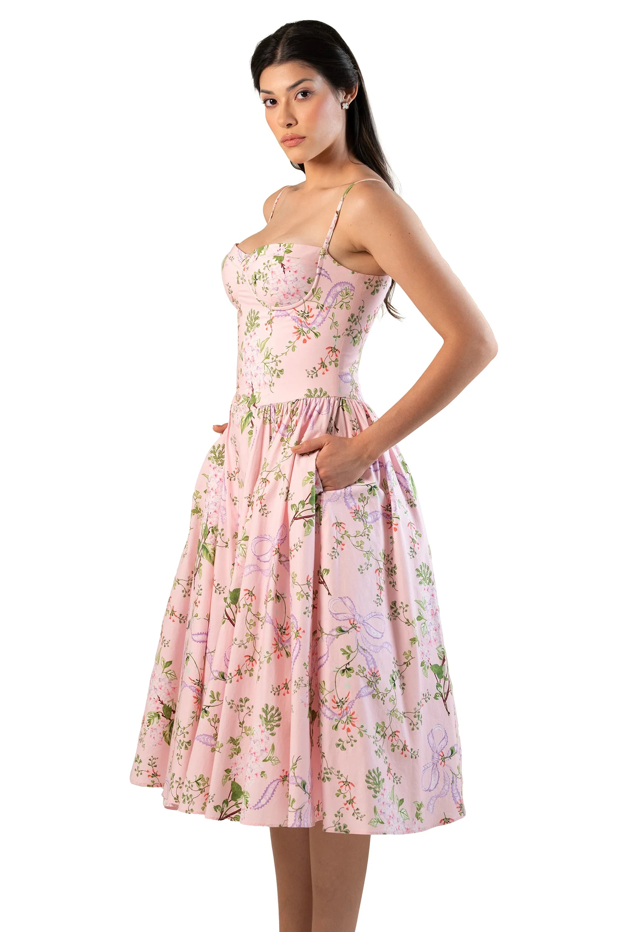 model in pink floral sweetheart midi, thin straps, hands in pockets