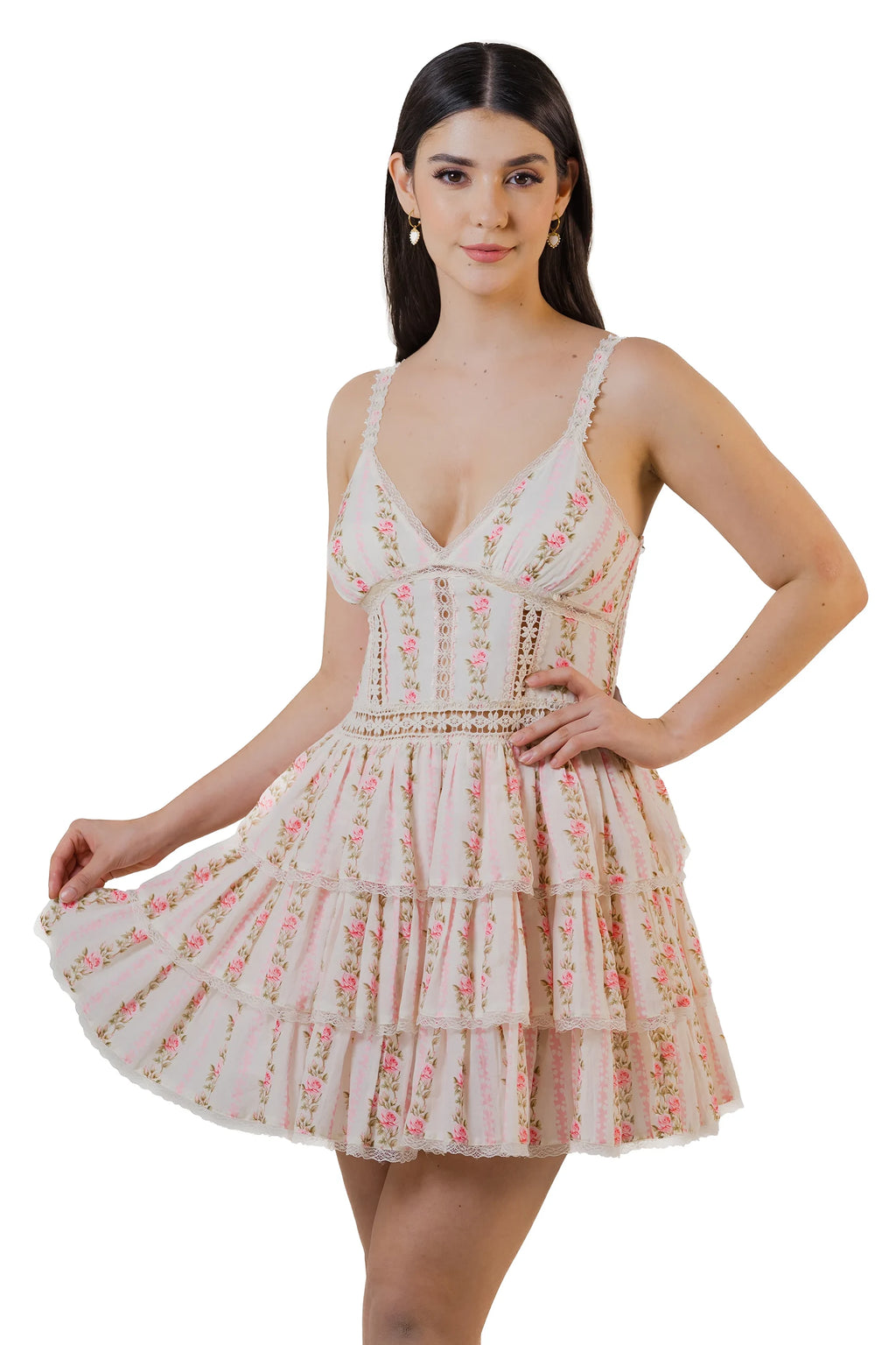 Women in pink floral lace tiered mini dress playfully holding hem, feminine summer outfit