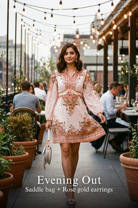 Woman in Pretty Pixie beige paisley puff-sleeve mini dress styled for an evening out