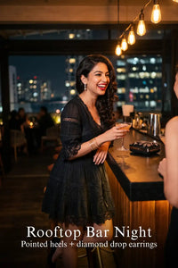 Pretty Pixie black lace-trim pleated v-neck tiered dress for rooftop bar night.