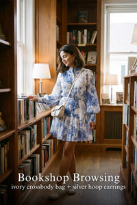 Woman in Pretty Pixie indigo toile button-front belted tiered mini dress styled for a bookshop browsing
