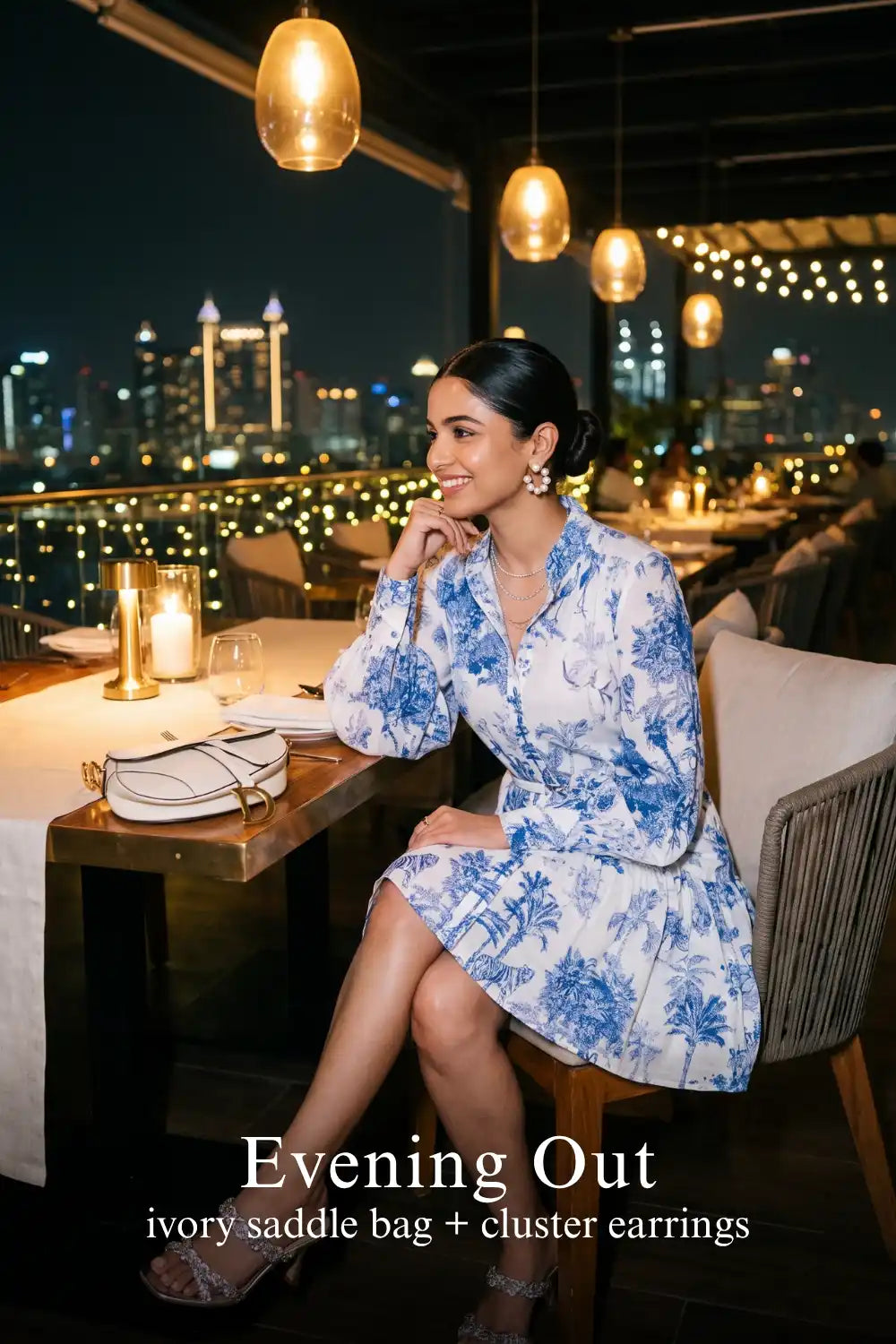 Woman in Pretty Pixie indigo toile button-front belted tiered mini dress styled for an evening out