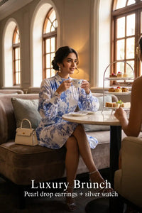 Woman in Pretty Pixie indigo toile button-front belted tiered mini dress styled for a luxury brunch