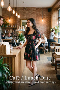 Woman in Pretty Pixie black floral puff-sleeve smocked mini dress styled for a cafe lunch date