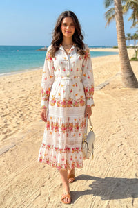 oman standing on a tropical beach wearing Pretty Pixie's ivory floral lace-panel belted shirt midi dress with collared button placket and long sleeves