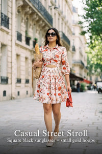 Woman in Pretty Pixie ivory floral cotton button-down belted mini dress styled for a casual street stroll