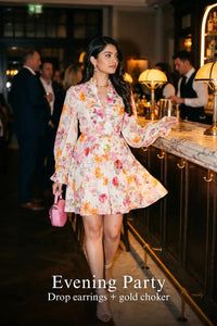 Woman in Pretty Pixie ivory floral long-sleeve button mini dress styled for an evening party