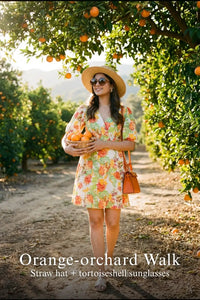 Woman in Pretty Pixie ivory floral puff-sleeve belted mini dress styled for an orange orchard walk