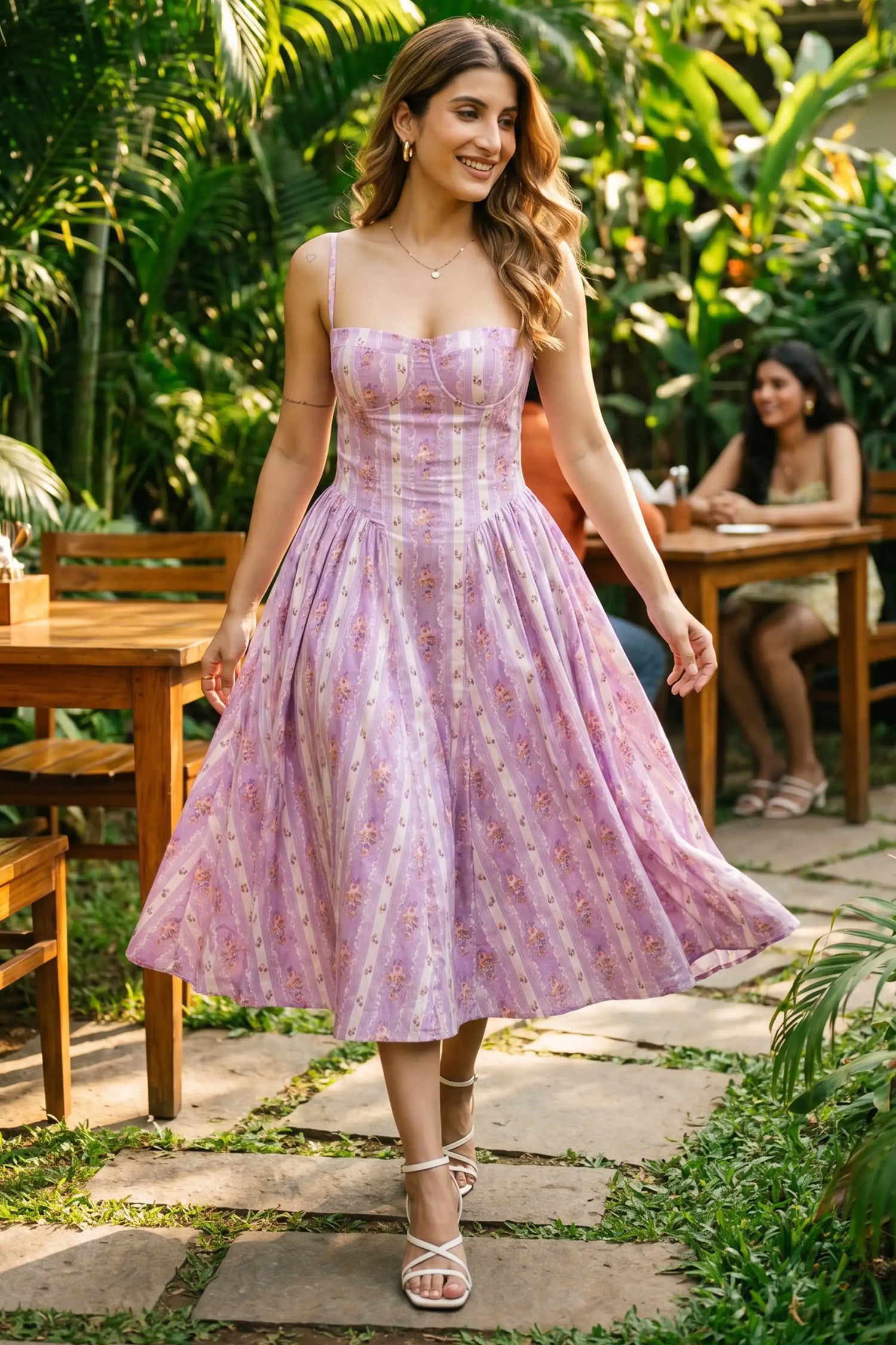 Woman dining at a garden restaurant wearing Pretty Pixie's lavender lilac striped floral corset midi dress