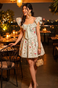 Woman at a rooftop dinner wearing Pretty Pixie's mint off-shoulder floral ruffle mini dress