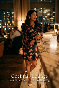 Woman in Pretty Pixie navy floral puff-sleeve belted mini dress styled for a cocktail lounge