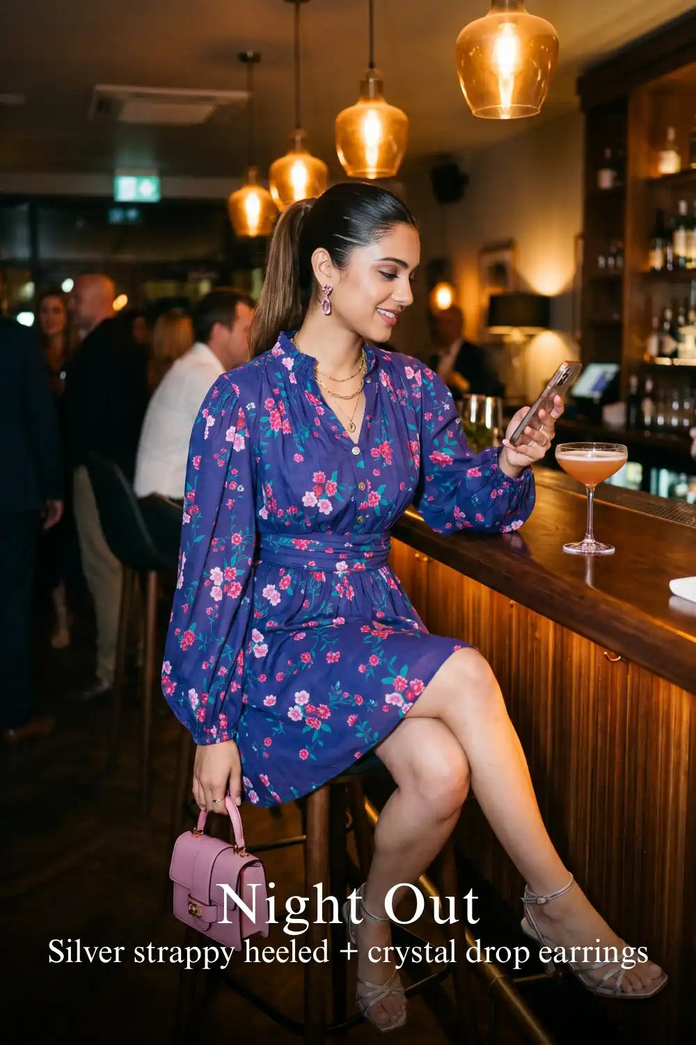 Woman in Pretty Pixie royal indigo floral v-neck puff-sleeve belted mini dress styled for a night out