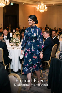 Woman in Pretty Pixie twilight rose navy floral ruffle hi-low midi dress styled for a formal event