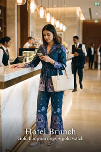 Woman in Pretty Pixie navy paisley belted blazer & flared pants co-ord set styled for a hotel brunch