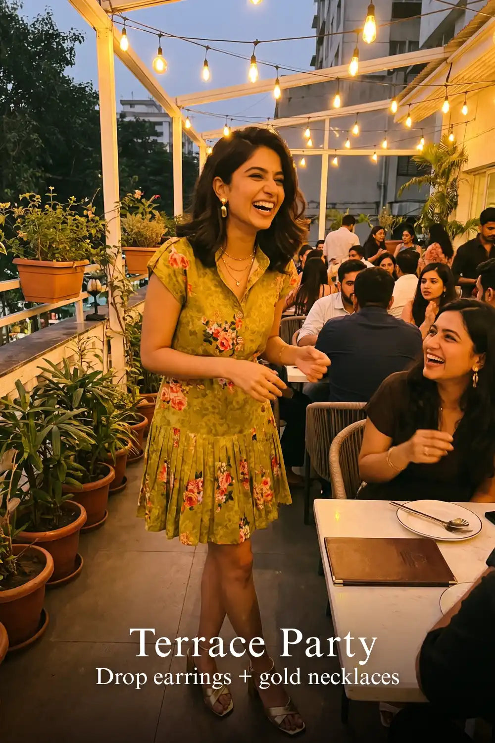 Woman in Pretty Pixie olive floral belted pleated shirt mini dress styled for a terrace party