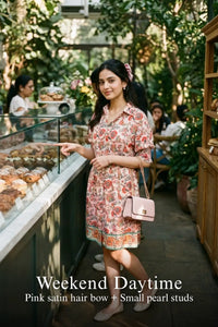 Woman in Pretty Pixie pink floral puff-sleeve belted mini dress styled for a weekend daytime