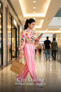 Woman in Pretty Pixie pink floral crop top & striped pants co-ord set styled for a city outing