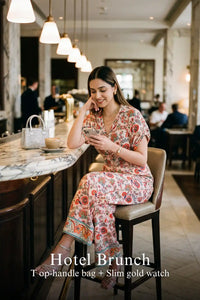 Woman in Pretty Pixie pink floral collared half-sleeve belted wide-leg jumpsuit styled for a hotel brunch