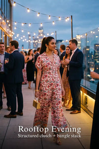 Woman in Pretty Pixie pink floral collared half-sleeve belted wide-leg jumpsuit styled for an evening outfit