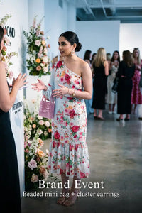 Woman in Pretty Pixie powder blue one-shoulder floral ruffle midi dress styled for a brand event