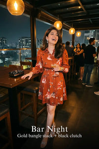 Woman in Pretty Pixie rust red floral button-down belted long sleeve mini dress styled for a bar night