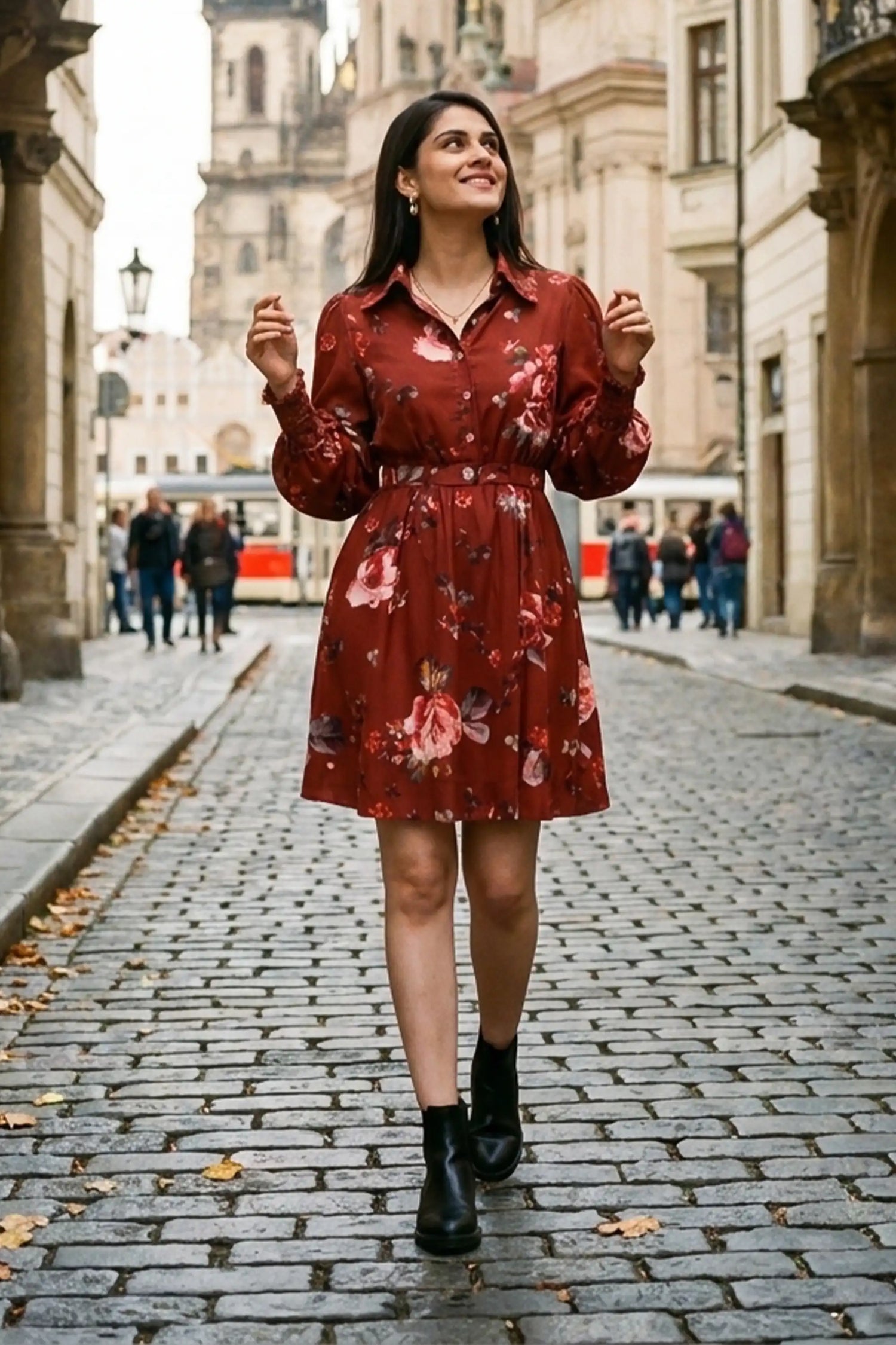 Woman in rust red floral button-down belted long-sleeve dress with black boots walking cobblestone street in Prague old town - Pretty Pixie travel wear