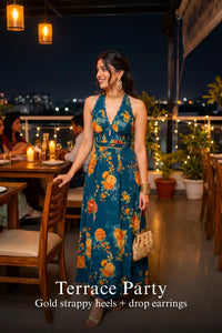 Woman in Pretty Pixie sunset crush royal indigo floral halter maxi dress styled for a terrace party