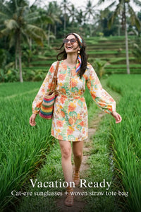 Woman in Pretty Pixie gardenia floral puff-sleeve smocked mini cotton dress styled for a vacation ready