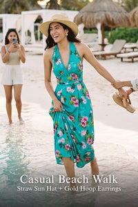 Woman in turquoise floral halter maxi dress with straw sun hat and gold hoop earrings walking on beach shoreline - Pretty Pixie vacation wear