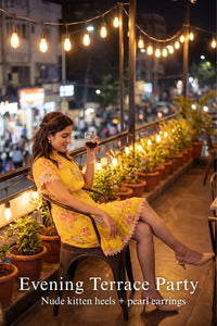 Woman in Pretty Pixie sunshine yellow floral smocked mini dress styled for an evening terrace party 3