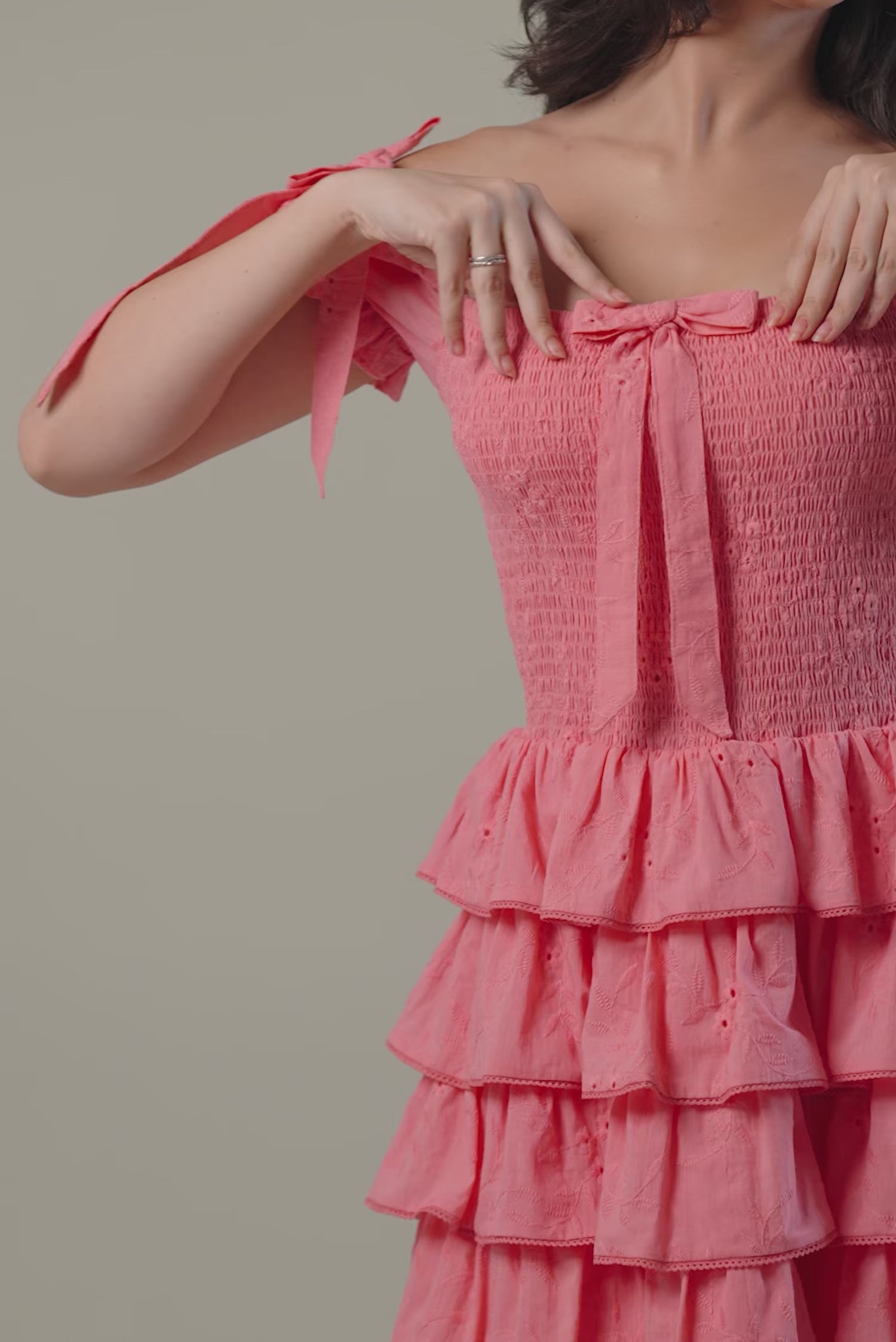 Women wearing pink off-shoulder ruffle mini dress with bow tie sleeves and smocked bodice