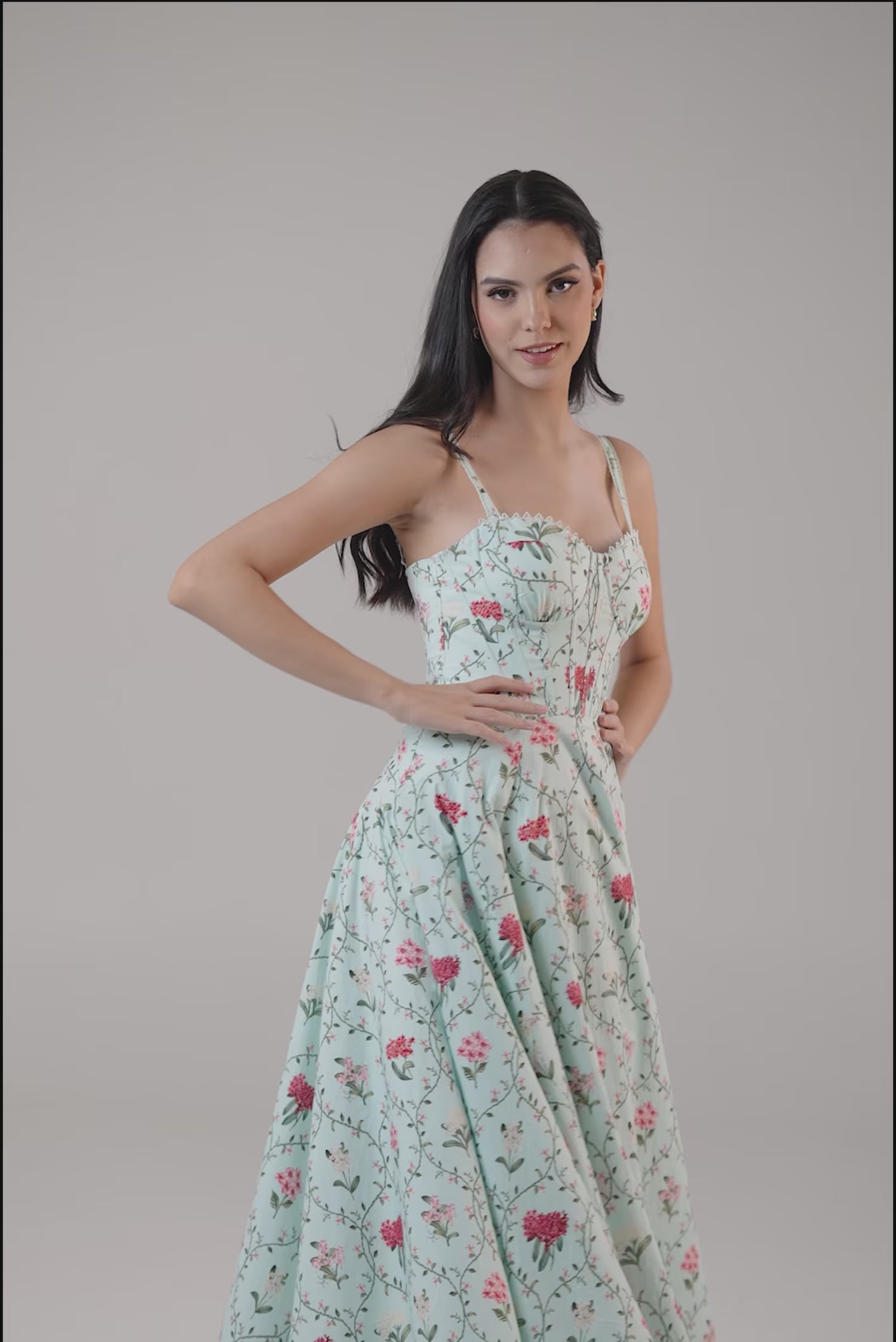 Woman wearing mint green floral corset midi dress with sweetheart neckline and flare hem