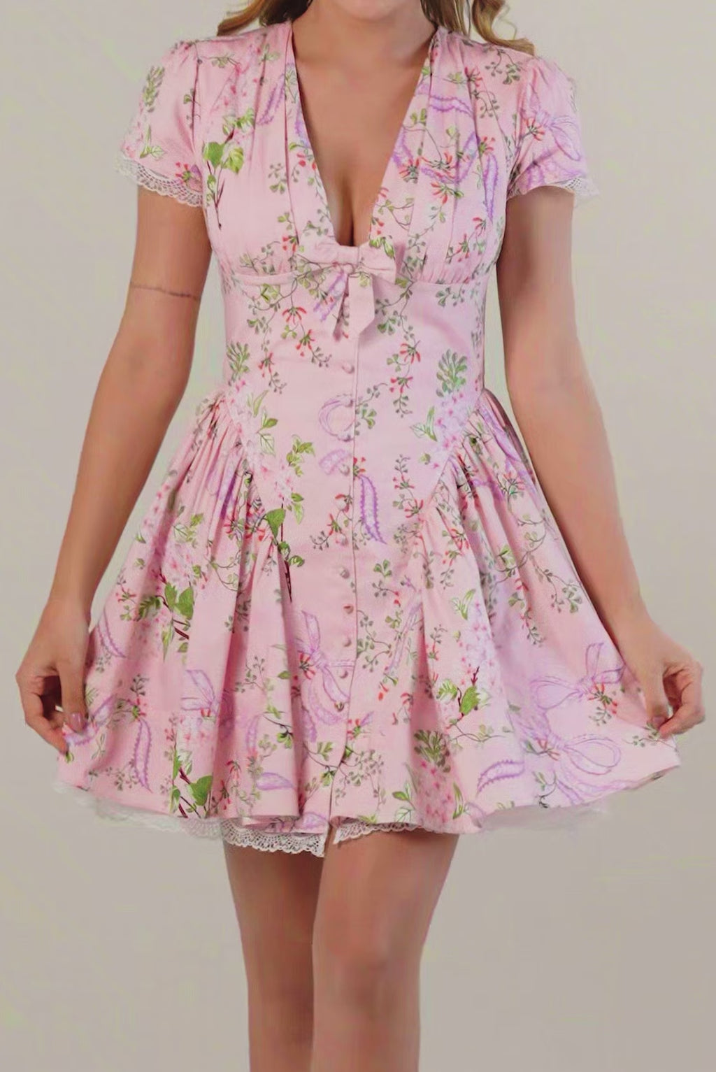 Model in pink floral short dress with lace trim, front view, v-neckline and puff sleeves for women