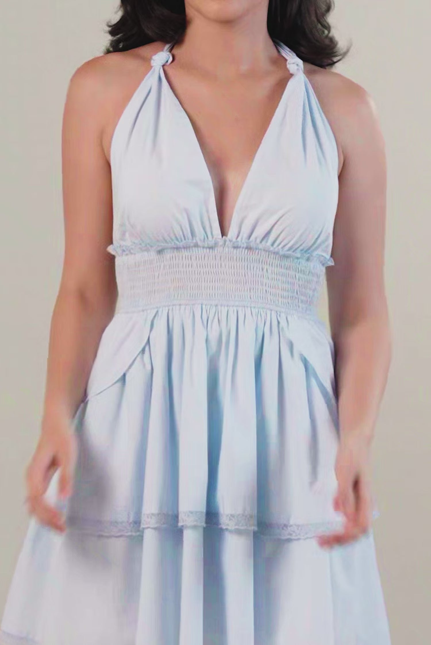 powder blue tiered halter mini dress with deep V-neckline, smocked waist and ruffled skirt.