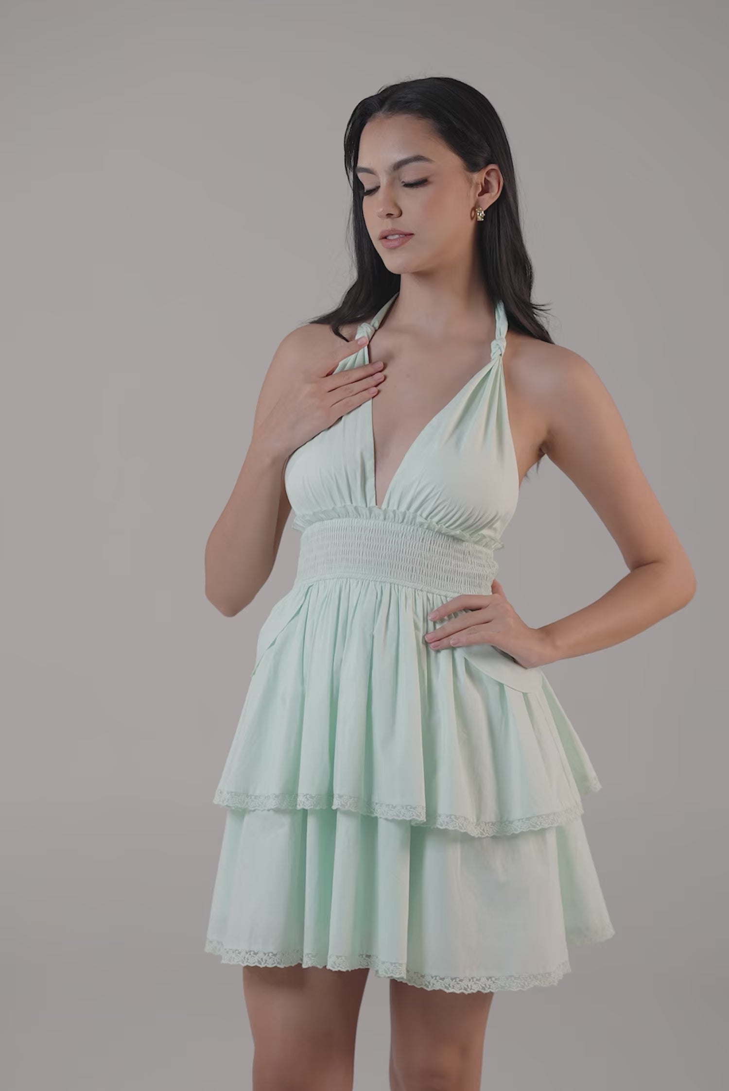 Women wearing a mint green halter-neck mini dress with tiered skirt and lace trim.