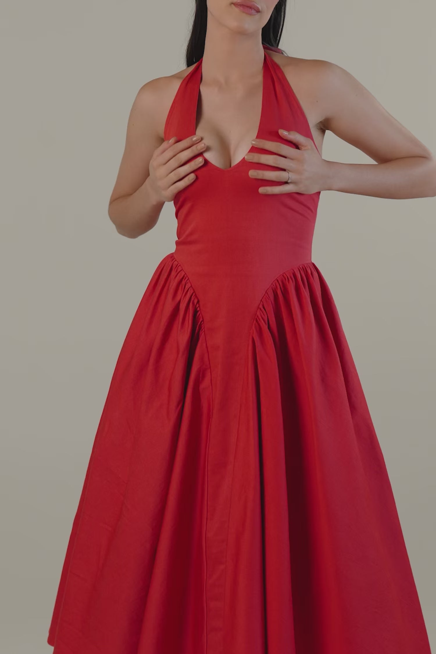 Women wearing red halter midi dress with flared skirt and sleeveless design