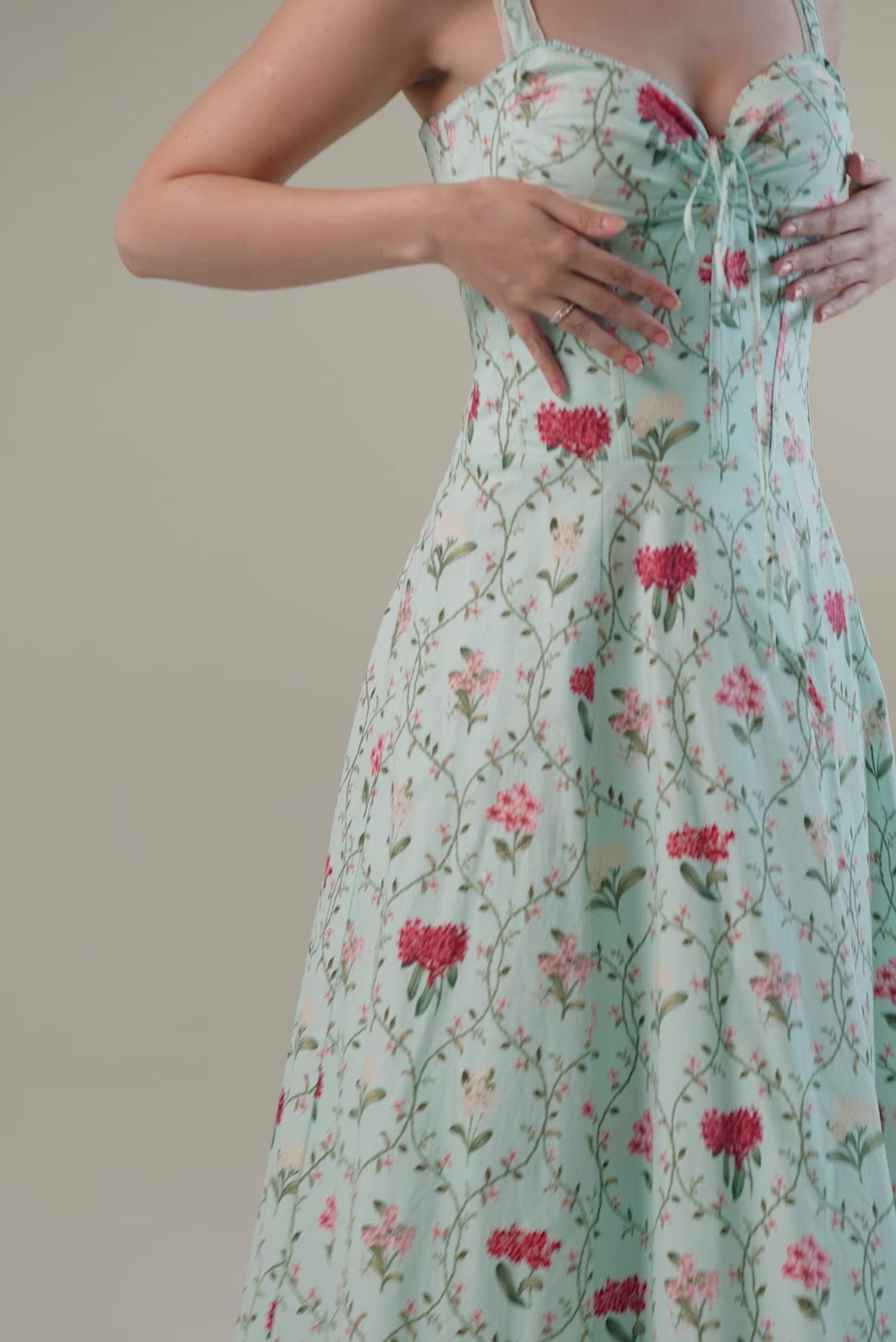 mint green floral corset maxi dress with red and pink blossoms, sleeveless design, and flowy hem.