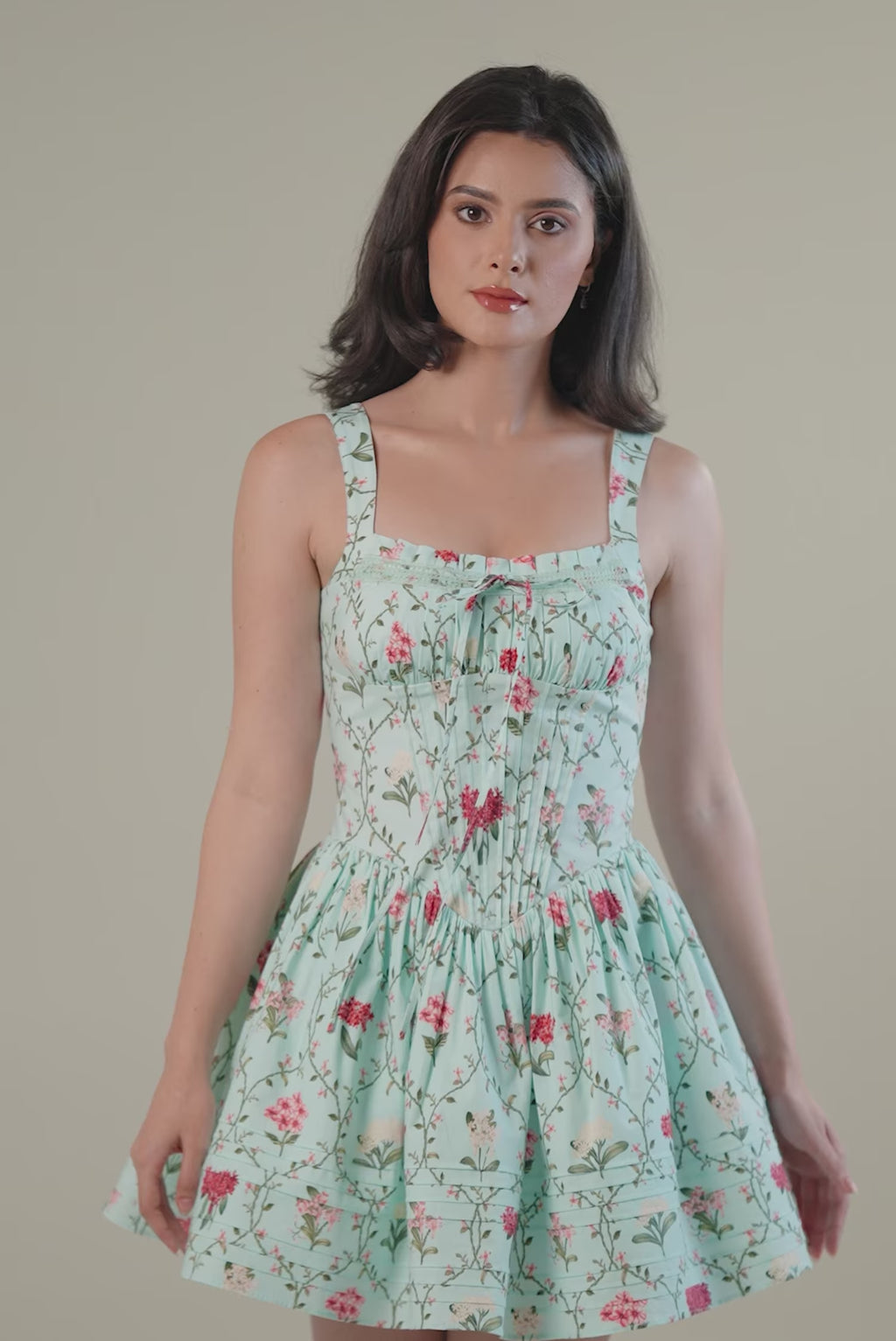 mint green floral mini dress showing fitted waistline and flare skirt