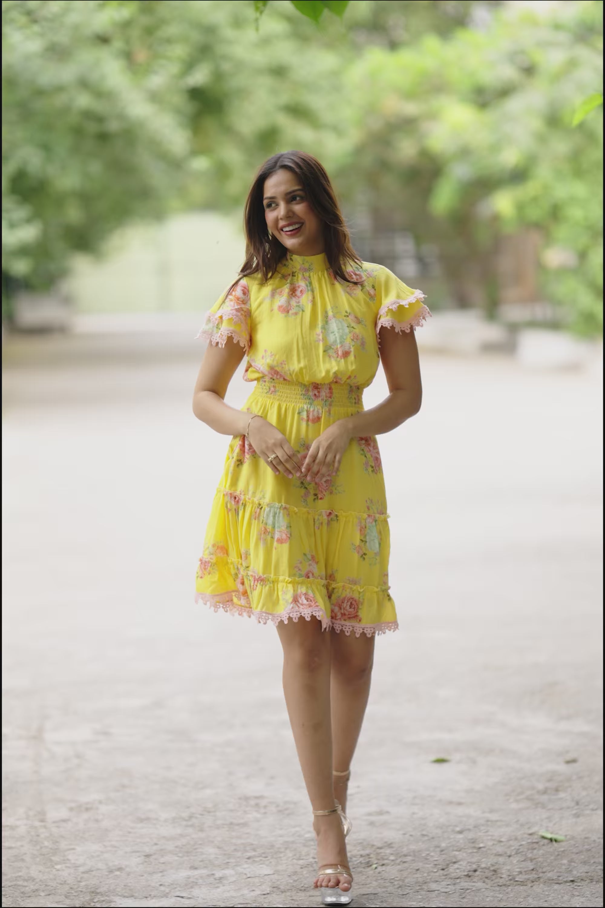 Smiling woman in yellow floral short dress 