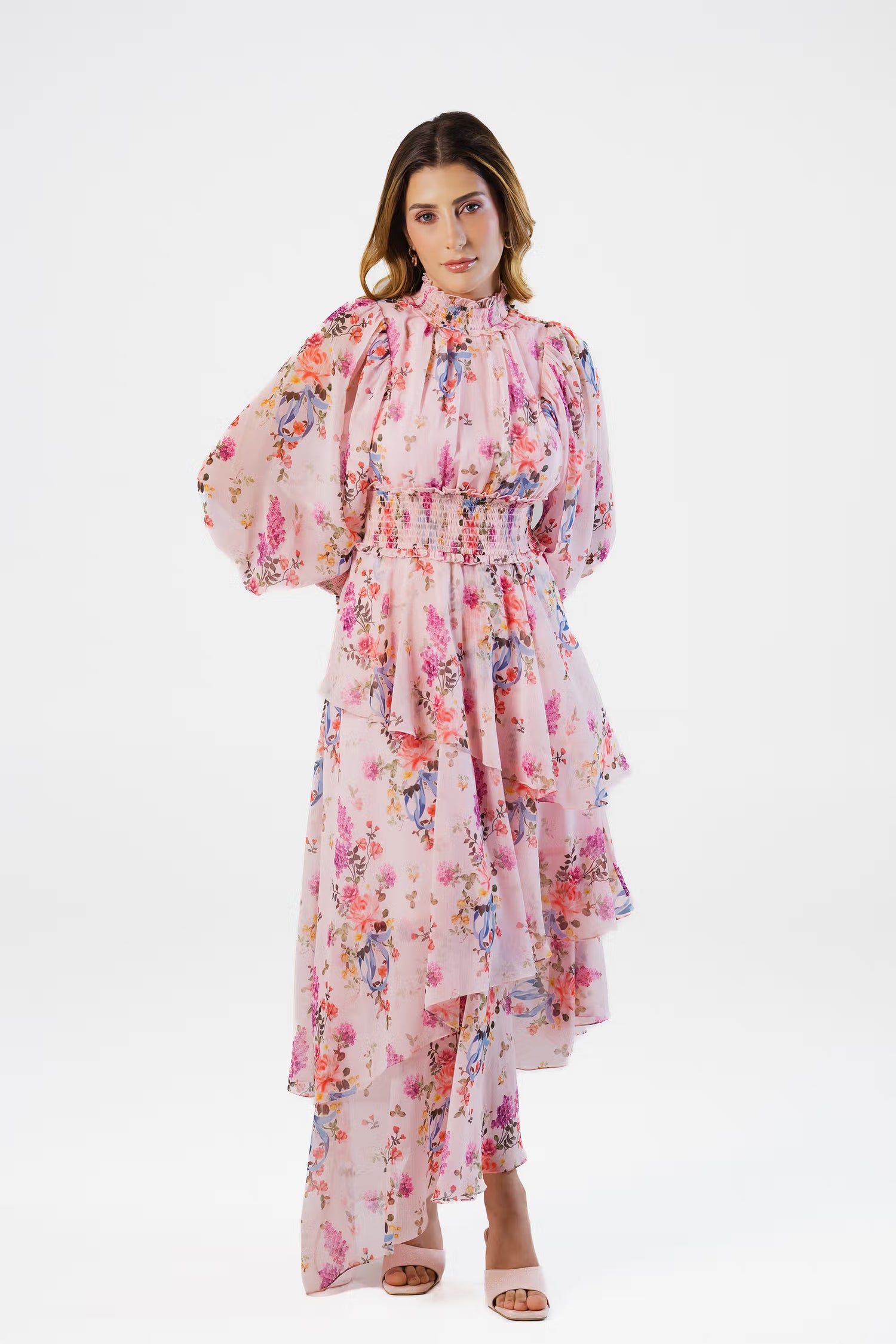 Woman in pink floral high neck layered maxi dress with long sleeves