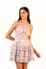 Women wearing pastel floral halter mini dress with ruffle skirt.