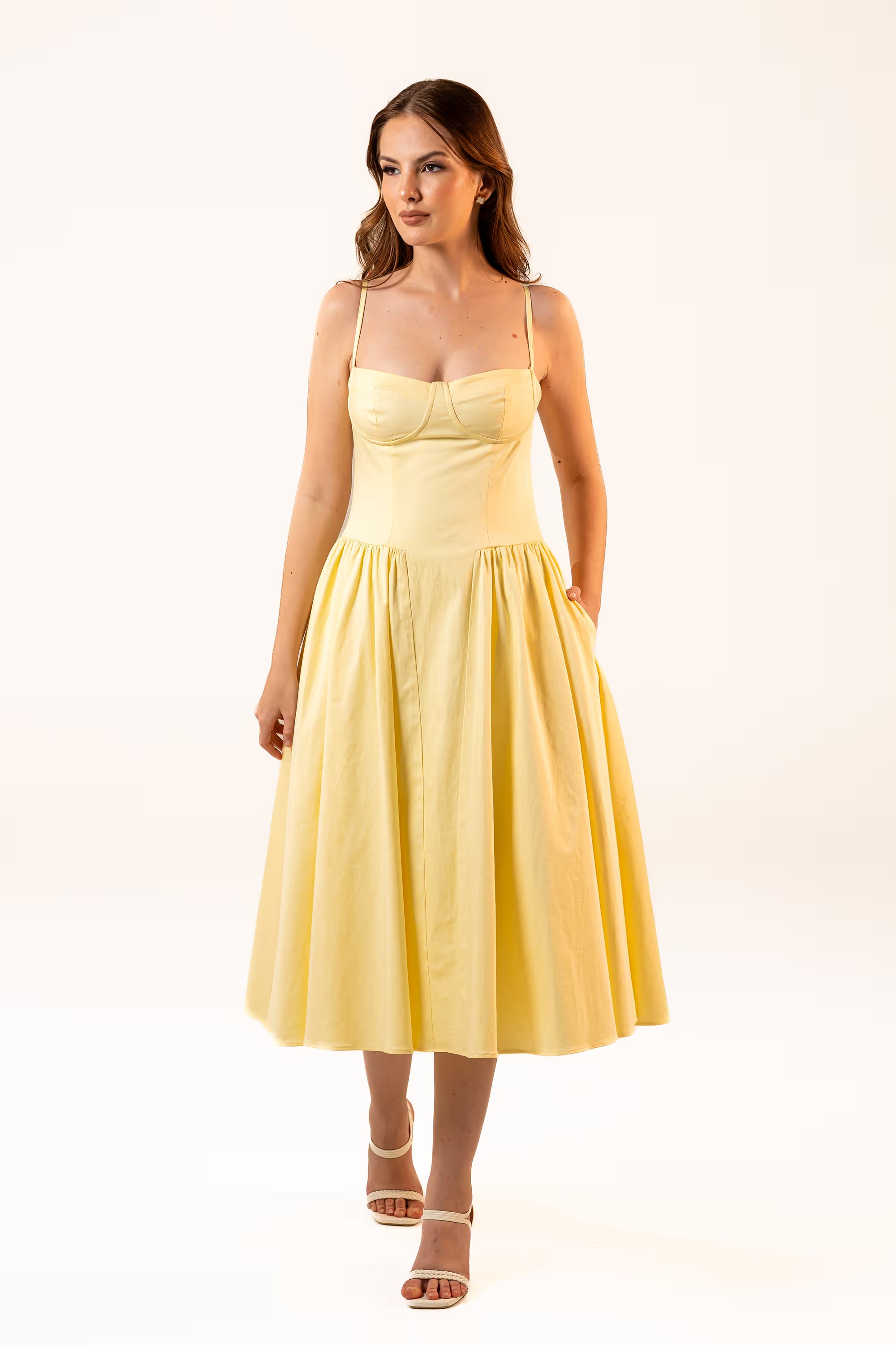 Woman in yellow midi dress with spaghetti straps and fitted bodice