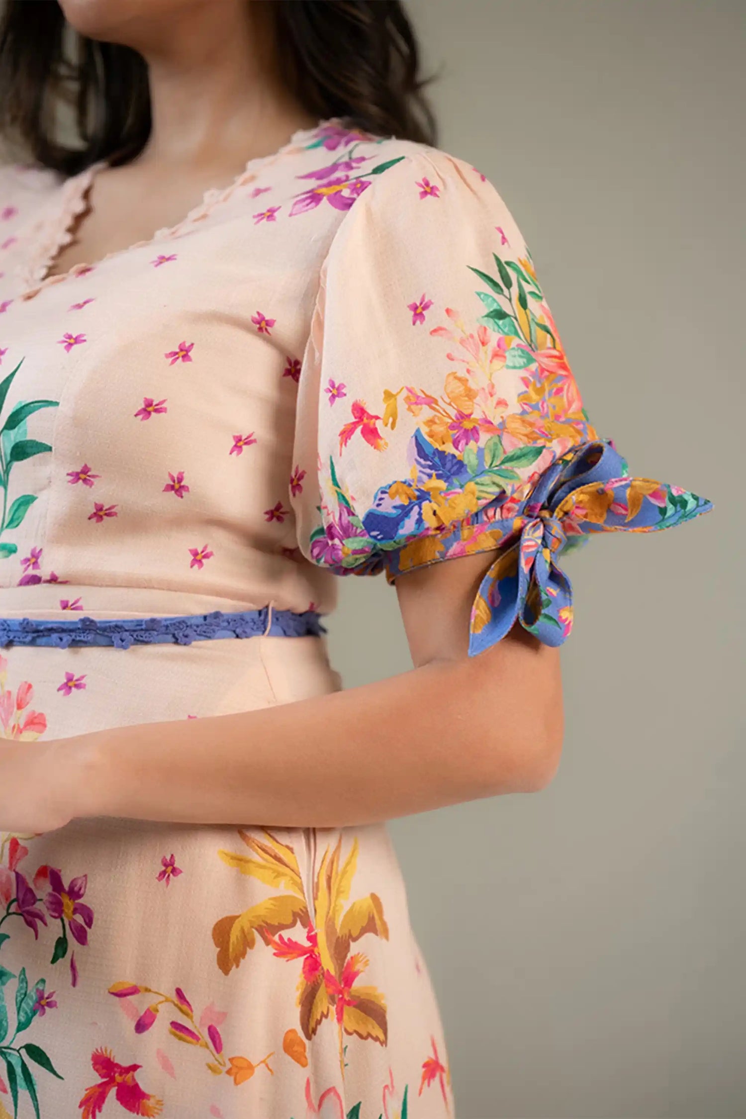 Closeup of sleeve bow detail on pastel floral short dress